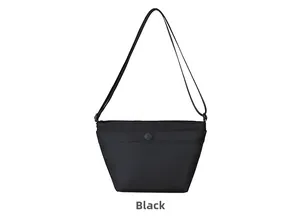 Primer plano detallado del bolso bandolera de nailon negro con bolsillo frontal con broche
