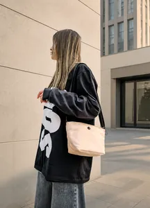 Bolso tipo cubo de nailon beige con correa ajustable negra de estilo callejero