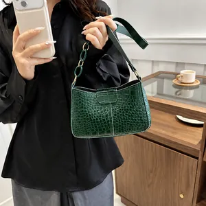 Dettaglio borsa sottobraccio verde scuro trama coccodrillo con catena e tracolla