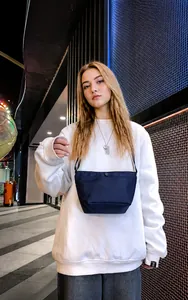 Detalle del bolso bandolera de nailon azul marino con cierre a presión en la calle