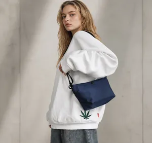 Detalle del bolso bandolera de nailon impermeable azul marino con estilo streetwear