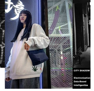 Foto estilo callejero de un suéter de punto blanco de manga larga con bordado de hoja