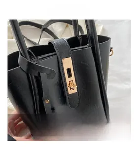 Dettaglio della borsa tote nera con hardware dorato e texture in pelle raffinata