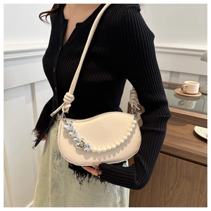 Vue détaillée du sac selle crème avec chaîne de perles et détails de cœurs argentés