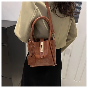 Dettaglio di una borsa a mano vintage marrone con fibbia dorata e targhetta fashion