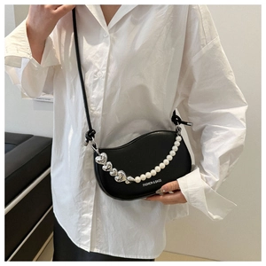Détail du sac selle hobo noir avec chaîne décorative en perles et cœurs métalliques
