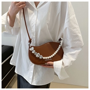 Détail du sac selle marron avec chaîne perles cœur et lettrage Fashion & Bags chic
