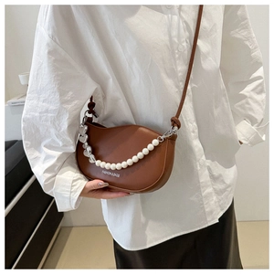 Détail d'un sac selle marron avec chaîne de perles et vue du porté sur mannequin