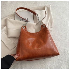Détail du sac bandoulière marron caramel avec lettrage mode et bandoulière en chaîne