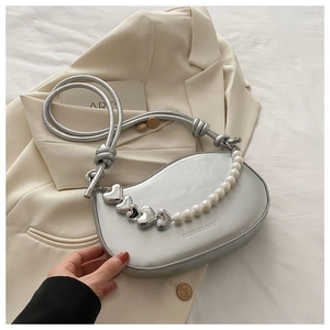 Détail du sac croissant argenté avec fini métallisé et chaîne de perles en cœur
