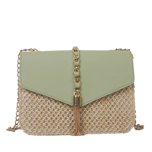Straw crossbody bag with light green leather flap and gold chain strap on white background
