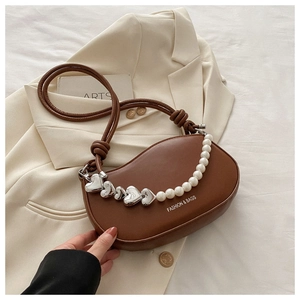 Détail du sac selle marron avec chaîne en perles de cœur et texte Fashion & Bags