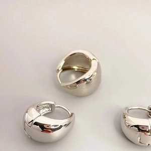 Macro shot of chunky 18K gold plated puffy hoop earrings with a mirror polished finish