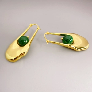 Macro detail of 18K gold plated earrings featuring smooth 3D curves and malachite stones