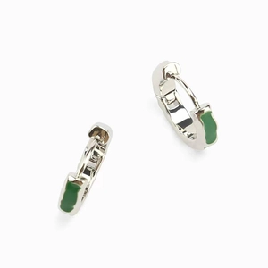 Detail of silver huggie hoop earrings with vibrant emerald green enamel inlay