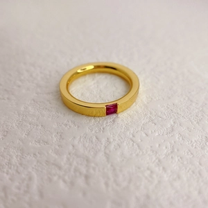 Minimalistischer Goldring mit poliertem Band und einem eingesetzten roten Edelstein