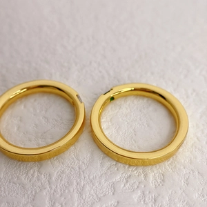 Minimalistische Goldringe mit Kristall und Smaragd-Edelstein auf weißem Hintergrund