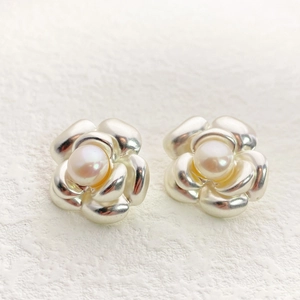 Close-up of elegant camellia flower stud earrings with layered petals and center pearl