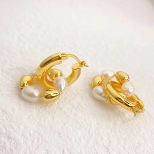Vue macro de boucles d'oreilles en laiton plaqué or 18K avec perles baroques