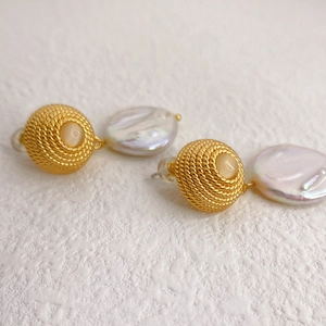 Elegant gold spiral drop earrings with baroque pearls and opal stones on a white background