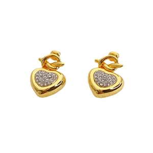 Elegant gold heart stud earrings with sparkling crystals and knot detail on white background
