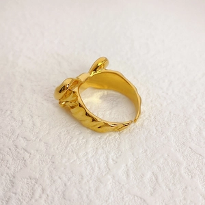 Makro-Detail des vergoldeten Schleifenrings mit Lava-Textur und 18K-Finish
