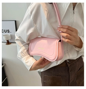 Side view of elegant pink PU leather shoulder bag worn by model over a white shirt