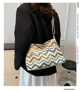 Modèle portant un sac à bandoulière aux motifs ondulés bleus, verts et orange-marron