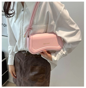 Detailed close-up of pink leather crossbody bag with Miss mini logo and elegant curved flap
