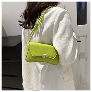 Detail showing the apple green crossbody bag with knotted strap and gold buckle