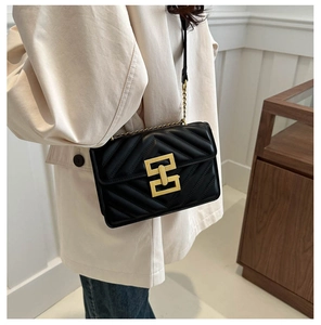 Detail of chevron quilted leather crossbody bag with elegant gold geometric metal buckle