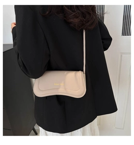 Chic beige leather mini crossbody bag shown worn over a black blazer for urban style