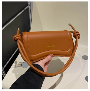 Detail of the brown semi-moon shoulder bag featuring a unique rope knot handle and Miss mini print