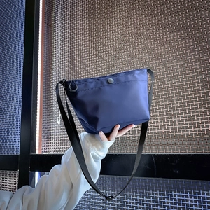 Bolso tipo cubo de nailon azul marino con correa ajustable y cierre de presión