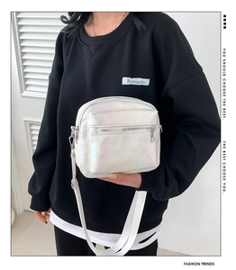 Detalle del bolso bandolera iridiscente con efecto láser y varios bolsillos con cremallera