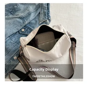 Inside view of white oxford crossbody bag showing large storage capacity for essentials