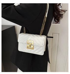 Detail of white V-quilted crossbody bag with a large gold square buckle on a black blazer