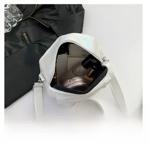 Vista detallada del interior de un bolso bandolera blanco irisado y su capacidad real