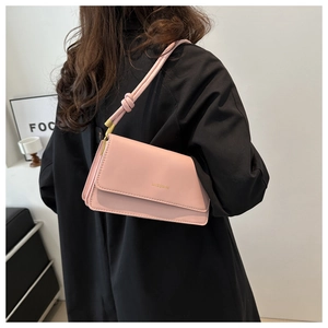 Detail of light pink crossbody bag with gold MISSMINI lettering and knot shoulder strap