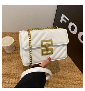 Close-up of white quilted leather bag featuring a gold clasp and chain strap detail