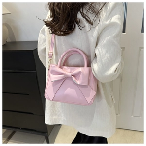 Pink bow bucket bag shown with white suit for size and styling on model back