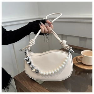 Sac selle beige chic avec chaîne en perles, charme cœur et cuir mat élégant