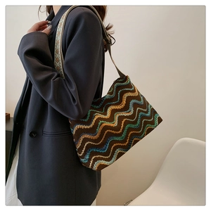 Vue détaillée du sac seau en toile tricotée avec large bandoulière brodée ethnique