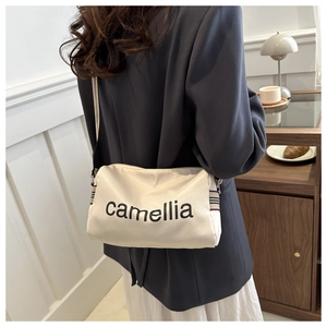 Minimalist beige nylon crossbody bag featuring stylish camellia print and woven strap