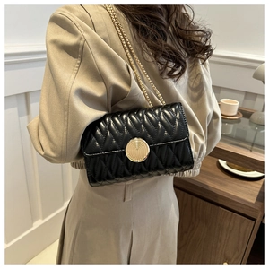 Détail d'un sac à main élégant en cuir matelassé noir avec boucle dorée en spirale