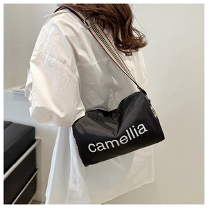Detail of black nylon puffer bag with camellia print and striped woven shoulder strap
