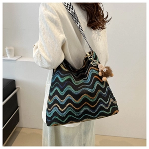 Ethnic bohemian woven bucket bag with colorful wavy patterns and geometric wide strap