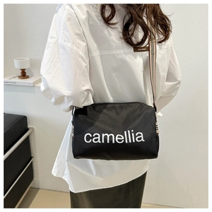 Lightweight black nylon pillow bag with camellia print and wide checkered shoulder strap