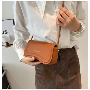 Brown faux leather mini crossbody bag with Miss mini logo shown on a model