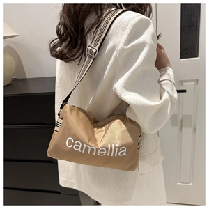 Detail of khaki nylon pillow bag featuring camellia print and striped wide strap